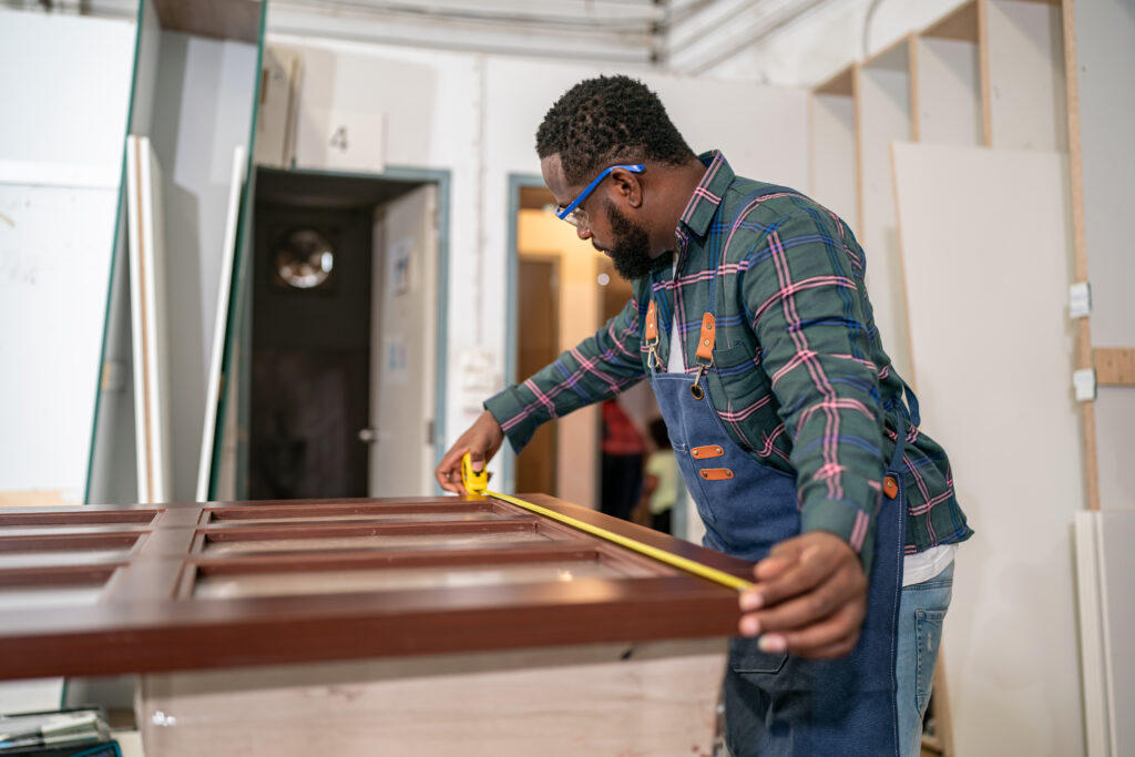 Finish carpenter measuring a door